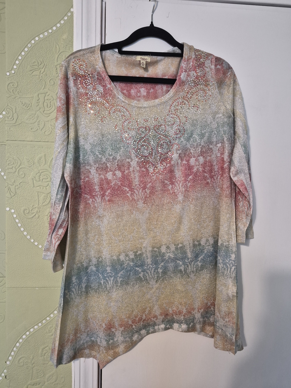 Reba brand top features a colorful pastel print with metallic thread and intrica